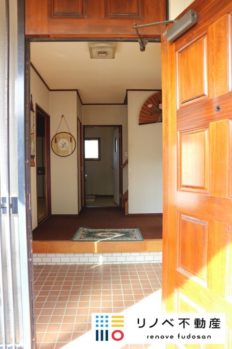 木製のドアを開くと、広々とした玄関スペースがあります。広い玄関は、家の解放感を感じられます。リノベーションでシューズクロークを造作するのもよいと思います。