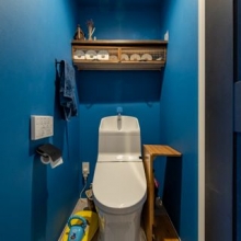【トイレ】引き締まった色合いのクロスが印象的。収納棚付きです。