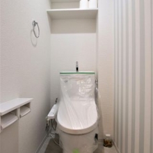 ストライプのアクセントクロス♪トイレの上部には棚があり、トイレットペーパーなどのストックを置くことが