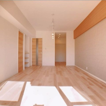 南向きのバルコニーから光が差し込む明るいリビング。落ち着いた色味のアクセントクロスで上品な空間に。